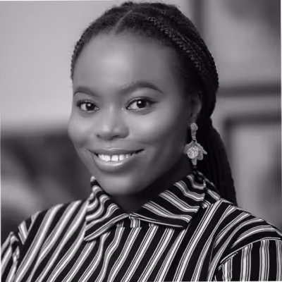 Smiling woman with braided hair wearing striped shirt and floral earrings.