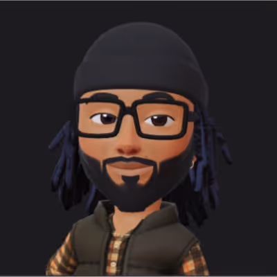 Avatar of a person with glasses, a black beanie, braided hair, a beard, and wearing a checkered shirt with a dark vest.